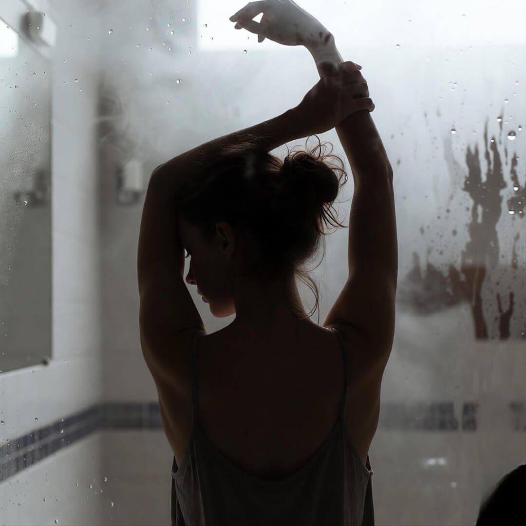 How Stress Affects PCOS — And What to Do About It Exhausted woman in yoga pose, foggy Seattle mirror reflection, eyes heavy with stress and PCOS.