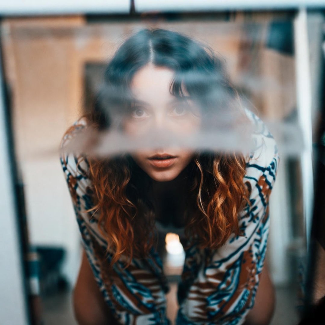 7 Diet Mistakes That Are Slowing Your Weight Loss A foggy bathroom mirror reflection: a person in a low crouch, peering intently at a scale amid steamy, cluttered U.S. apartment vibes, evoking weight loss guilt.