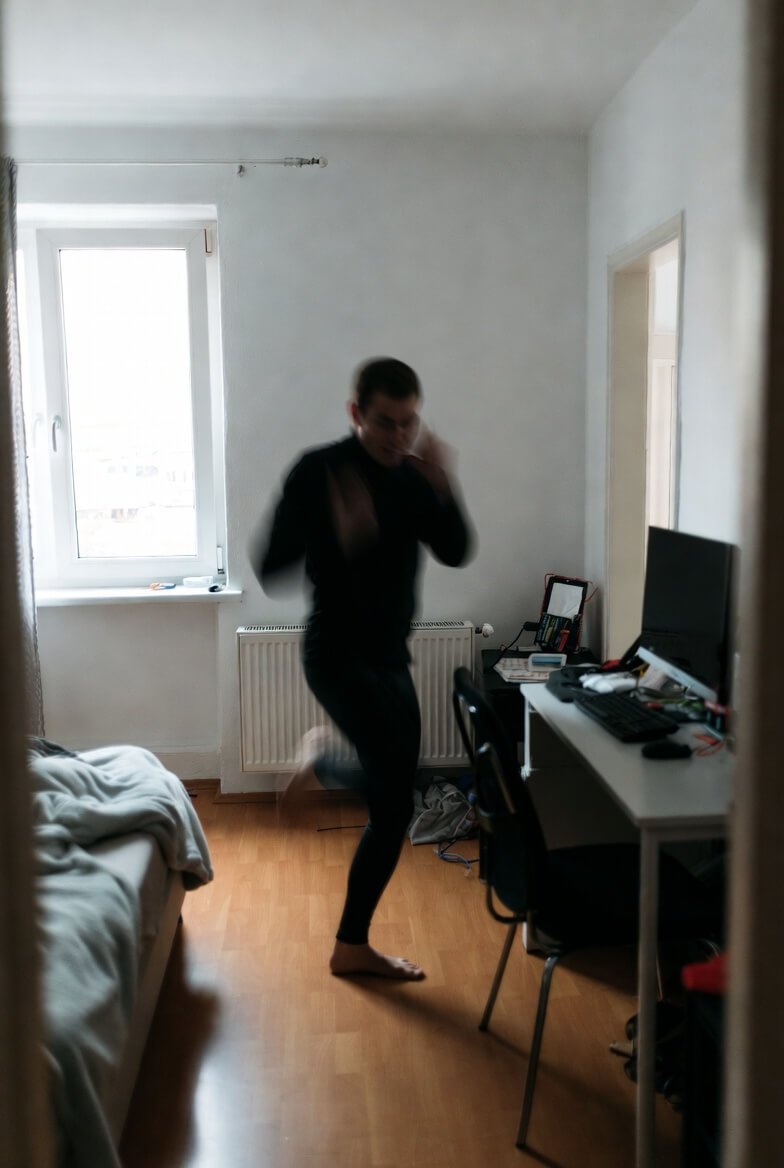 Blurred man exercising in cramped winter apartment (low angle) Blurred man exercising in cramped winter apartment (low angle)